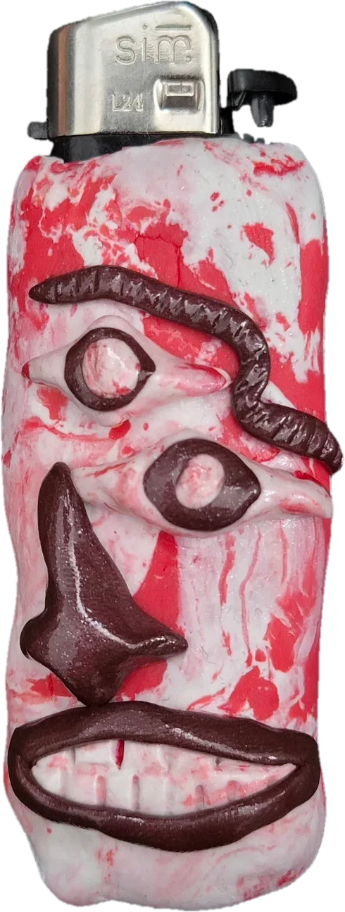 Feuerzeughülle aus rot-weiß marmorierter Knete mit kontrastierenden, dunkelbraunen Gesichtszügen. Das abstrakte Gesicht hat zwei versetzte Augen, eine geschwungene Augenbraue, eine große Nase und einen breiten Mund mit weißen Zähnen.